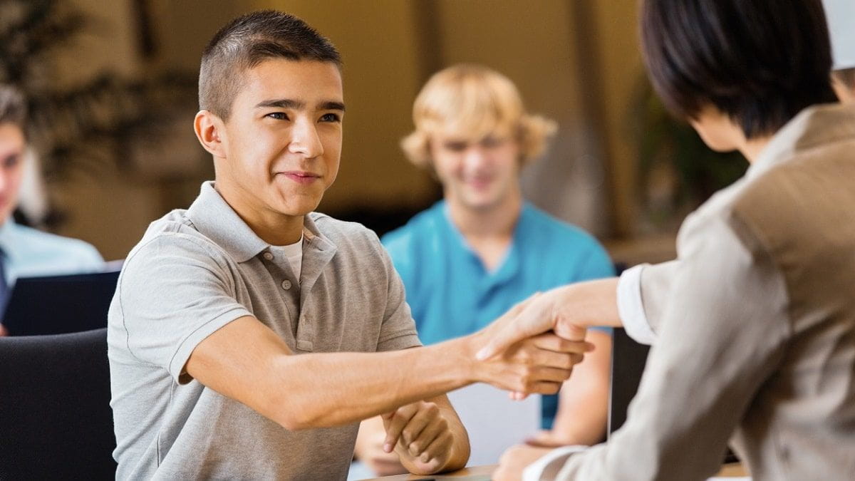 male teen shaking hands with adult
