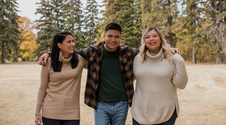 three-friends-pose-for-the-camera-in-an-open-field