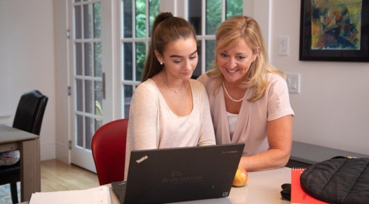 mom and daughter looking at laptop