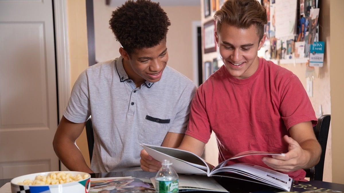 two boys looking at college brochures