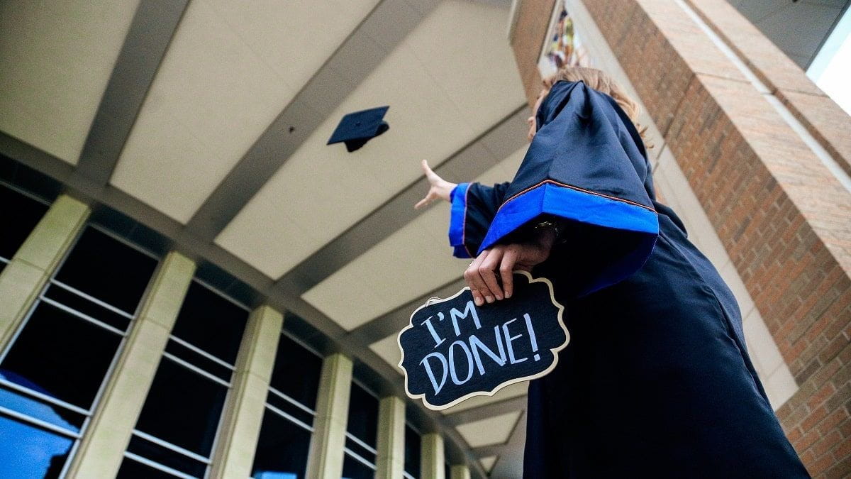 graduate holding sign reading I'm done