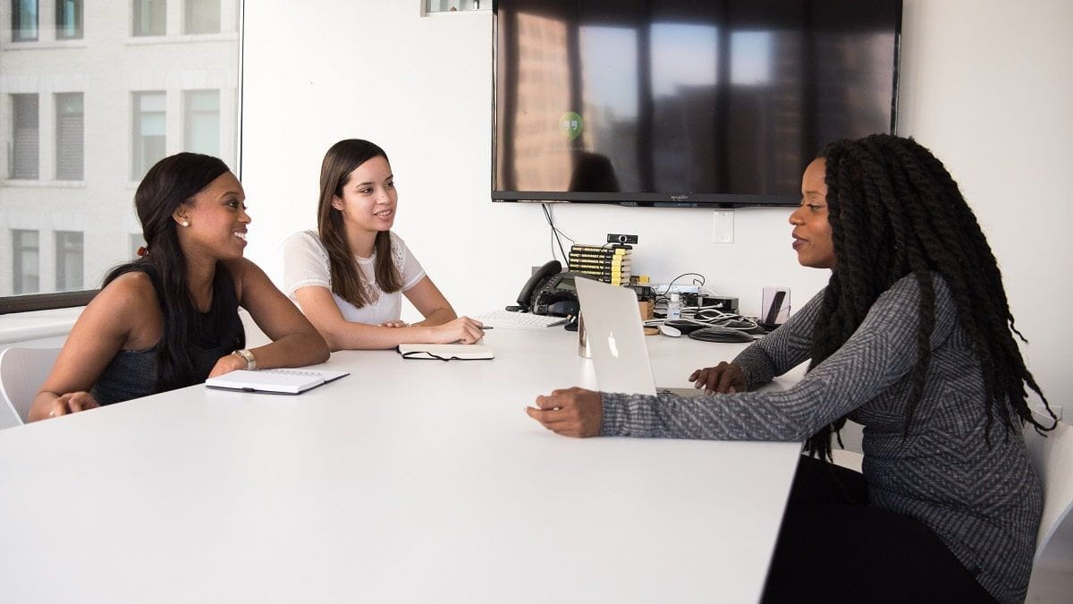 three women sitting at conference table