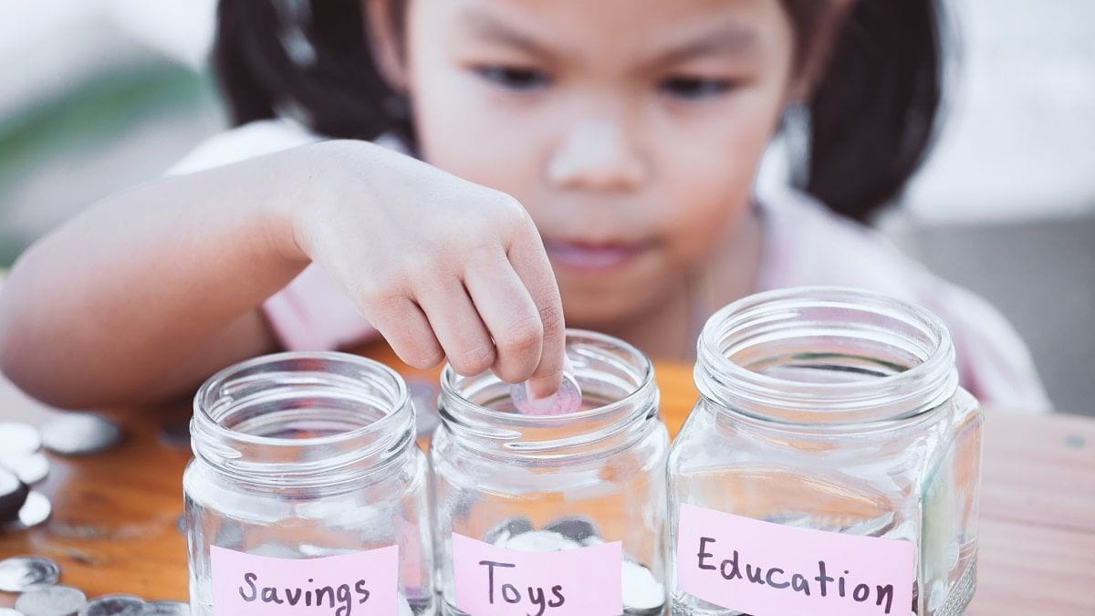young girl saving money in jars