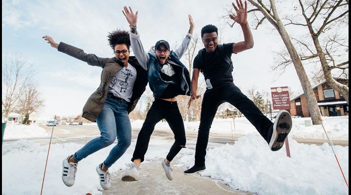 three college students jumping for joy outside in the show