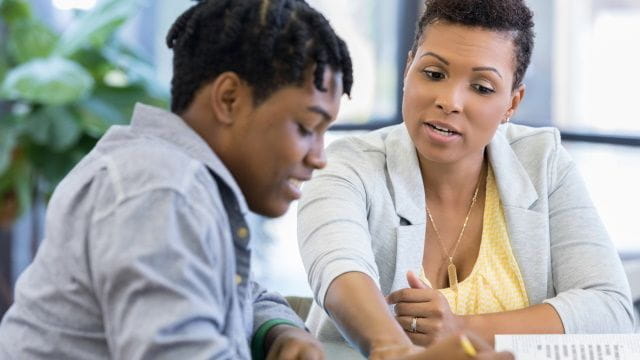 Counselor helps a student with paperwork
